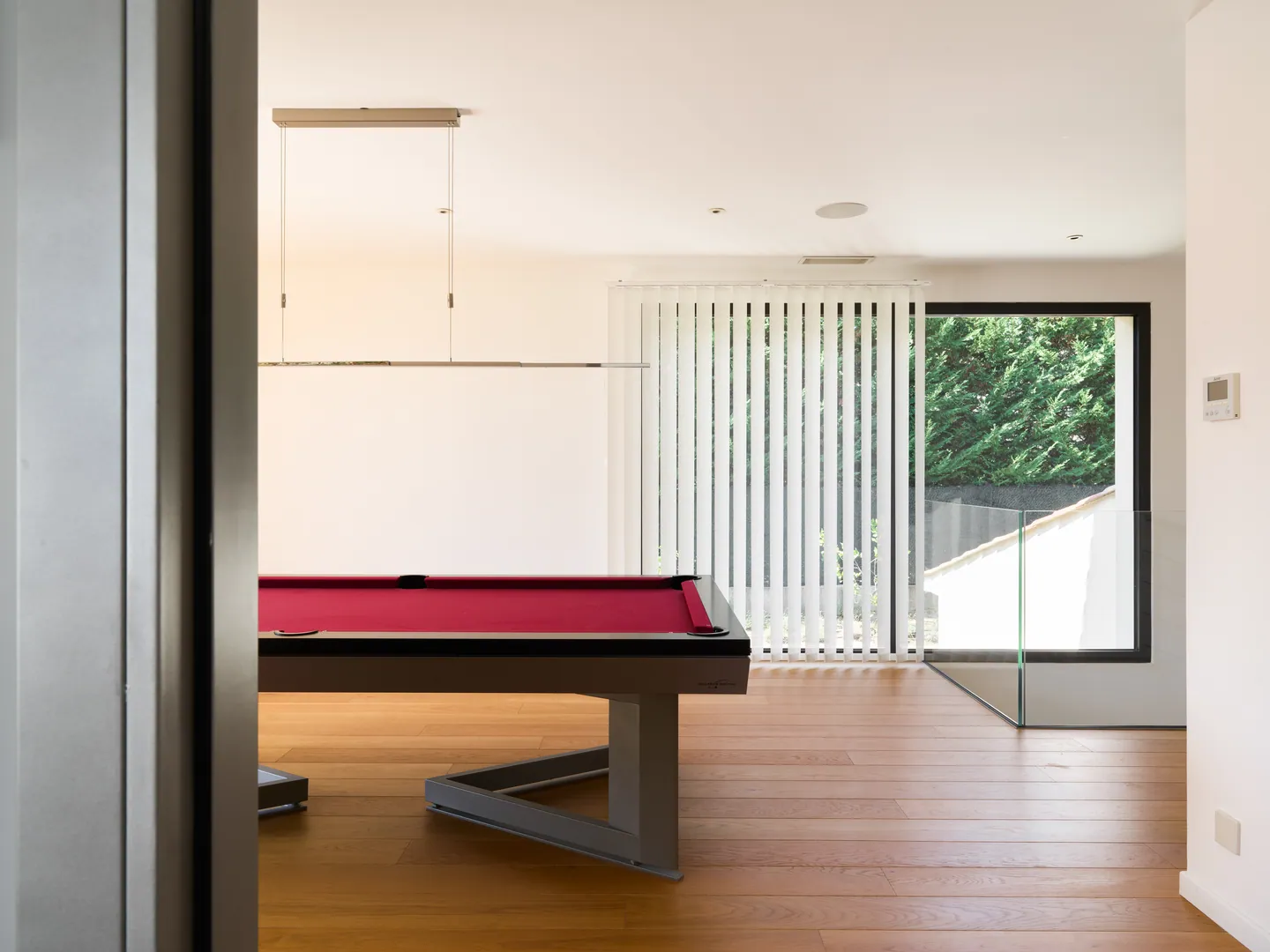 Table de billard rouge et parquet, vue depuis le palier