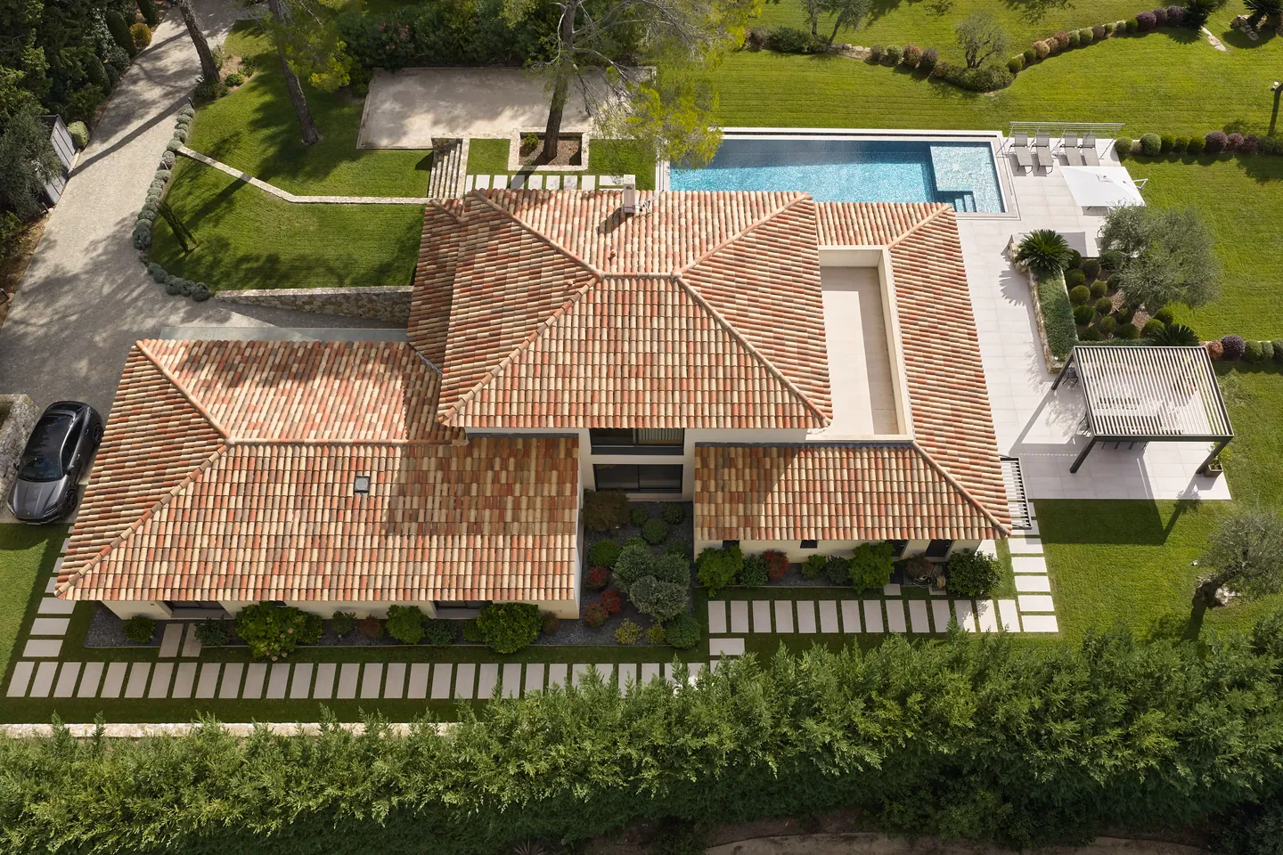 Vue aérienne de la toiture en tuiles avec patio, piscine et pergola