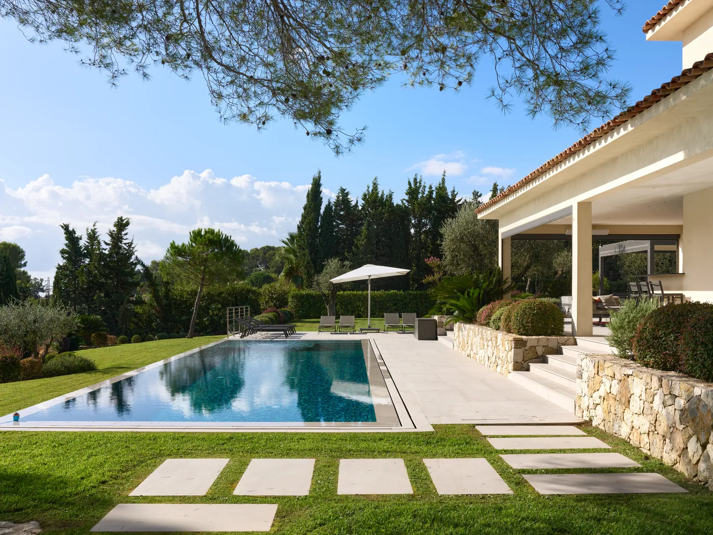 Piscine à débordement, pas japonais et terrasse couverte le long de la villa
