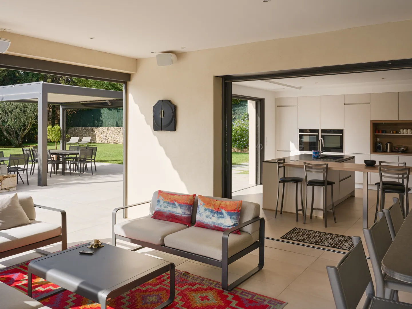 Salon de terrasse ouvrant sur la cuisine par de grandes baies coulissantes