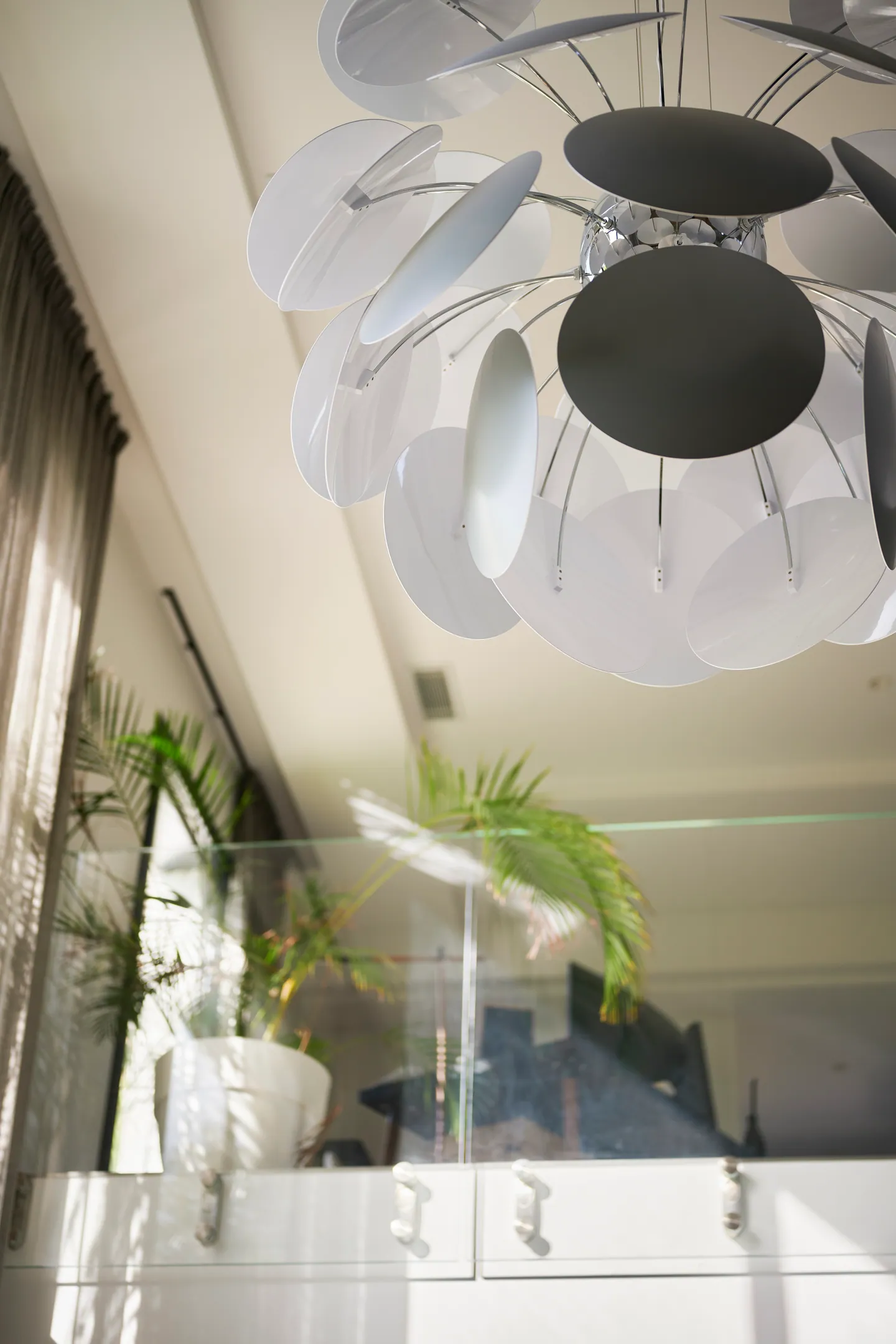 Suspension sculpturale à disques blancs et gris sous la mezzanine vitrée