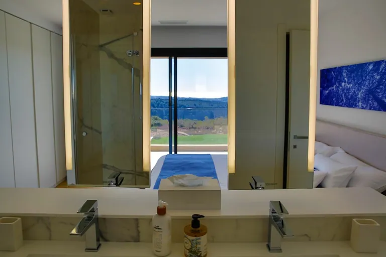 Double vasque et miroirs lumineux, douche à l'italienne en marbre