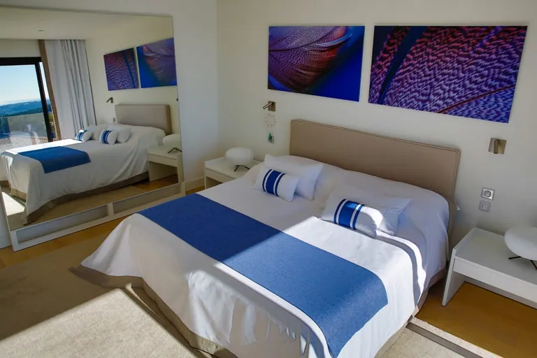 Lit double et grand miroir mural, œuvres aux tons bleus