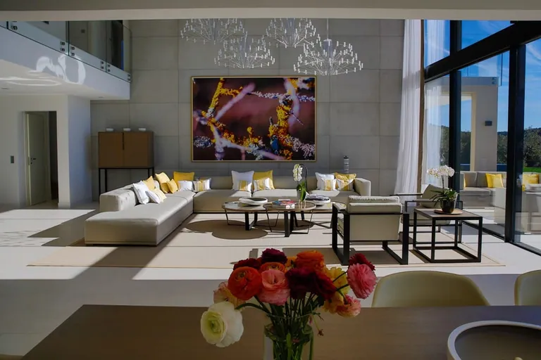 Le salon vu depuis la table à manger, grande toile sur un mur en béton