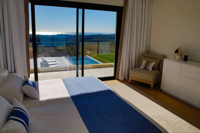 Vue depuis le lit sur la piscine, les collines et la mer