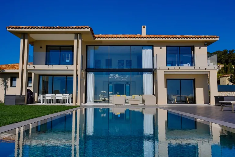 Façade principale symétrique se reflétant dans la piscine