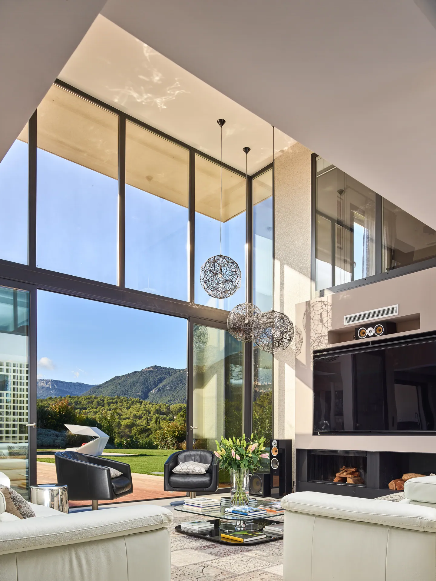 Living room's double-height window framing the mountain