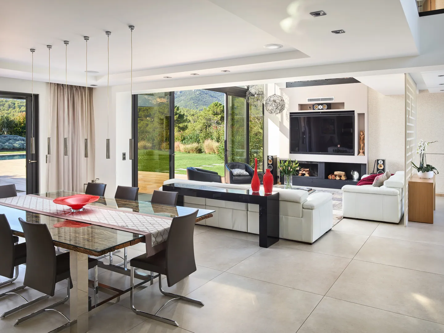 Wood and glass dining table, lounge and glass doors open to the garden