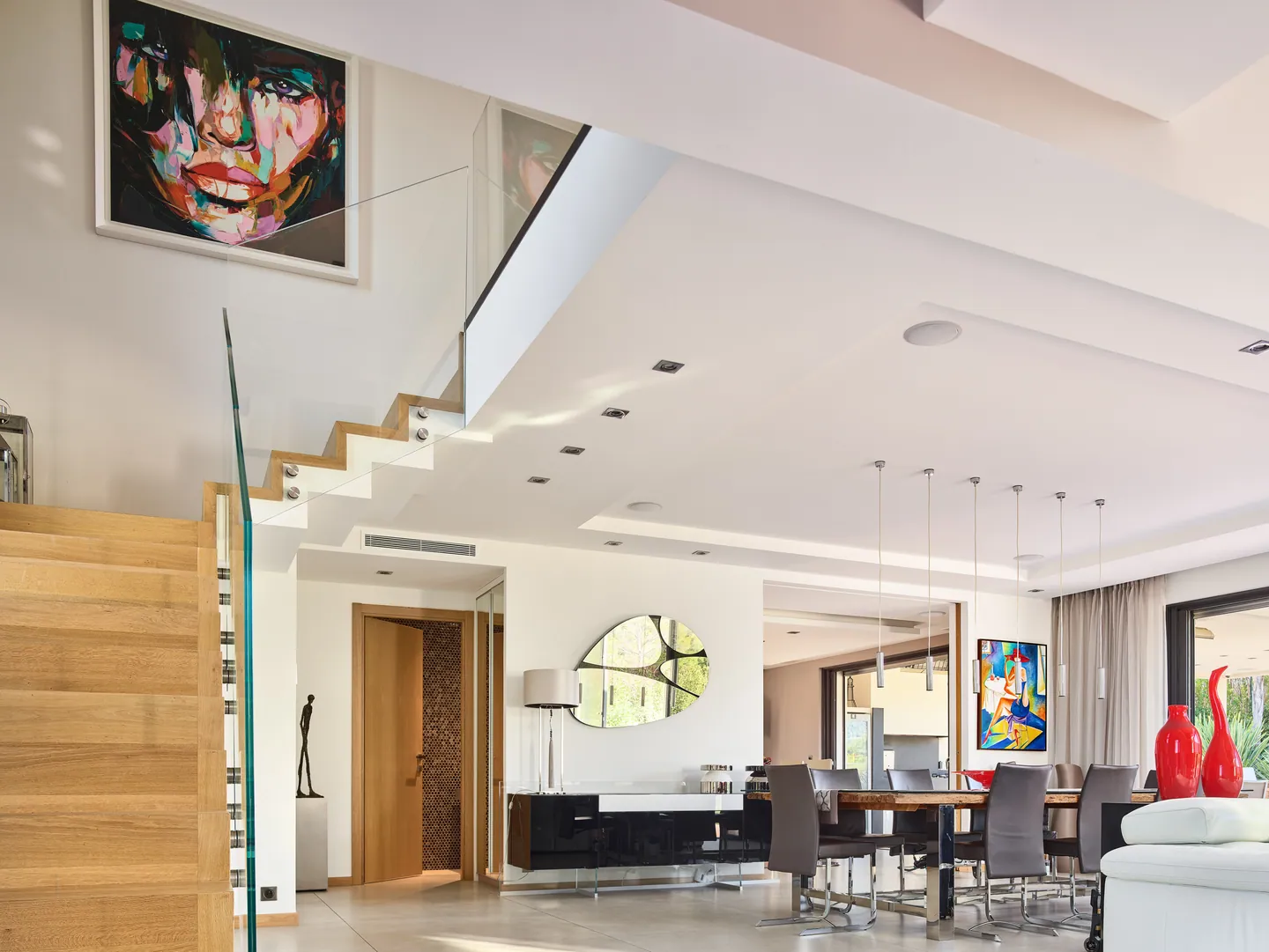 Wood and glass staircase, dining area and large colourful painting