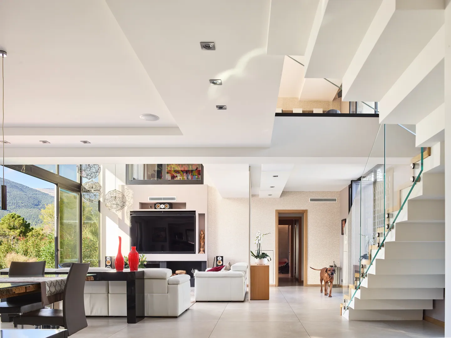 Open-plan living area with floating white staircase and mezzanine