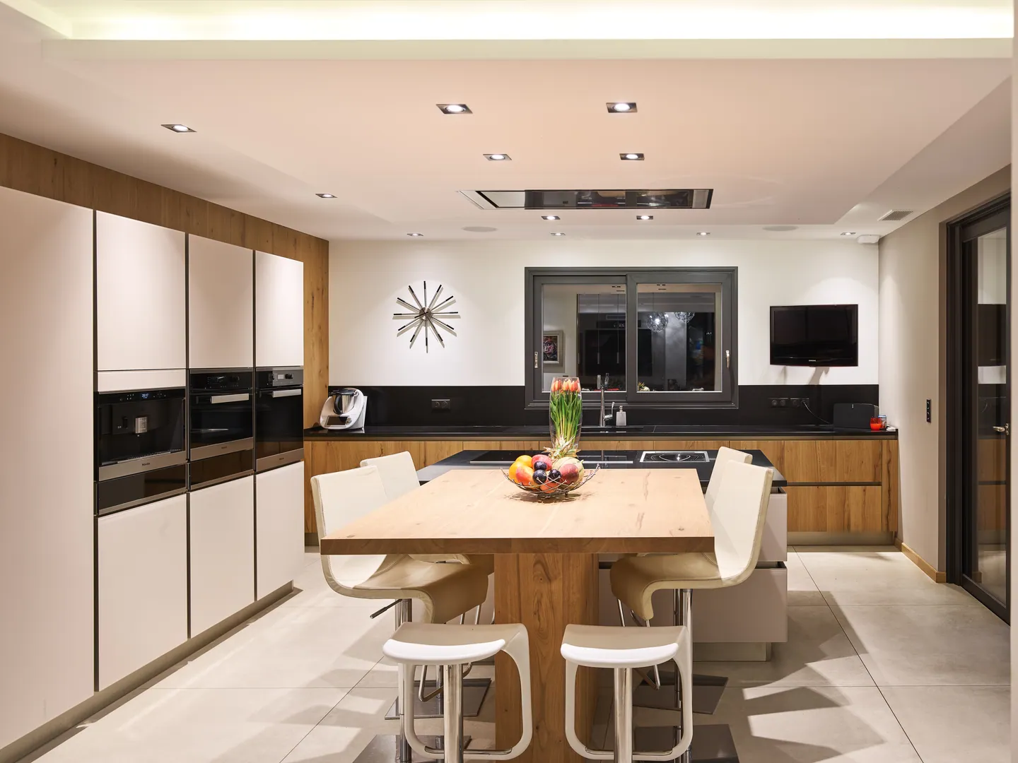 Kitchen with island, solid wood table and white high chairs