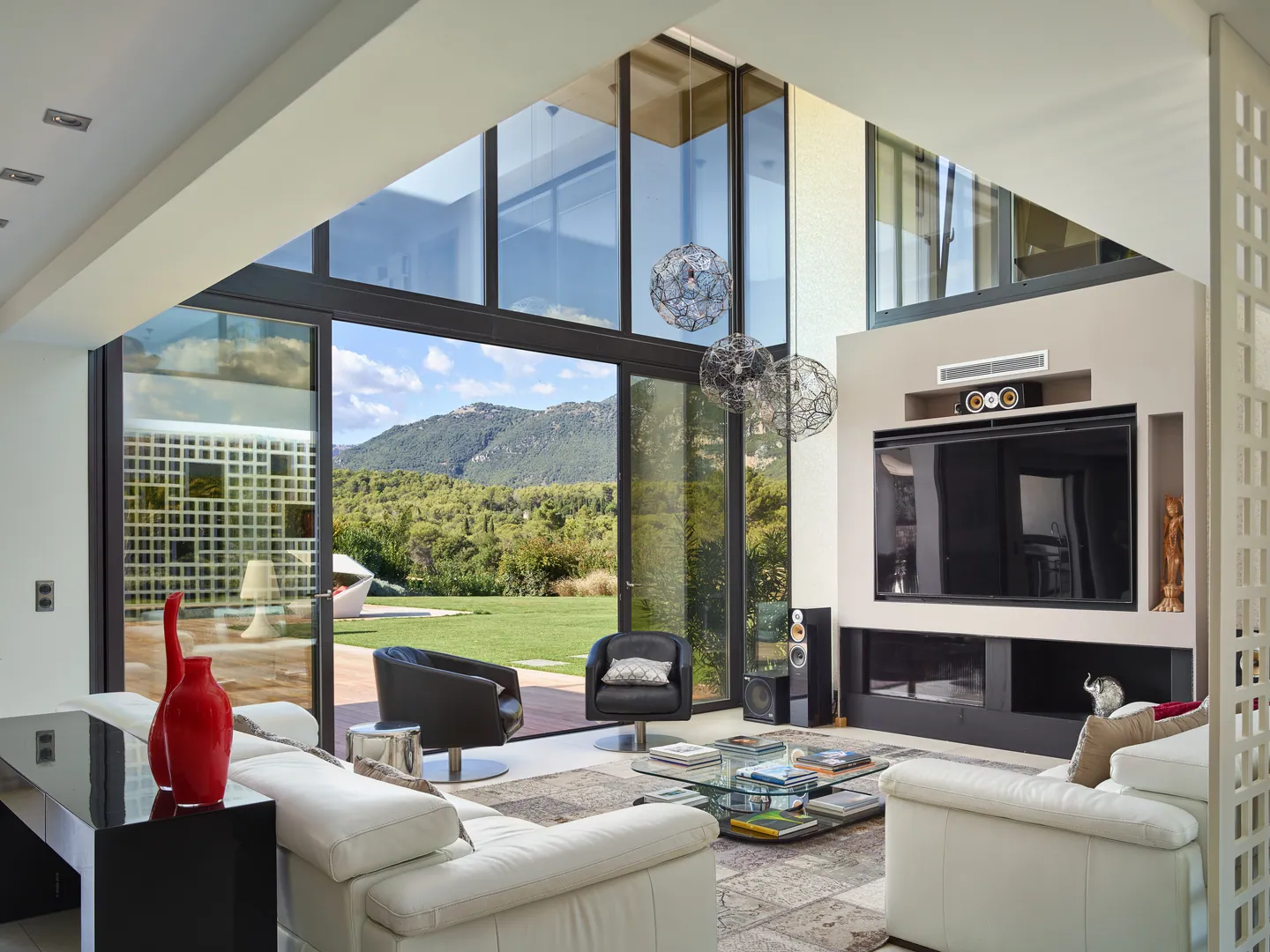 Living room under double-height glazing, fireplace and opening to the garden