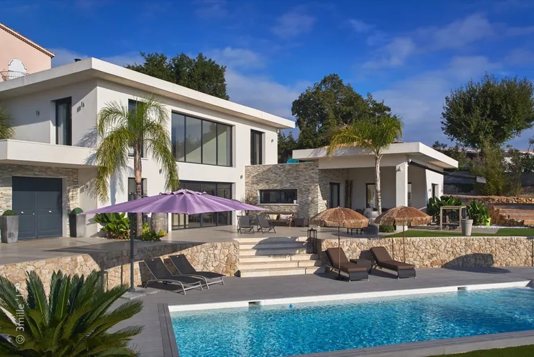 Pool-side facade: large glazed openings, stone steps and terrace overlooking the pool