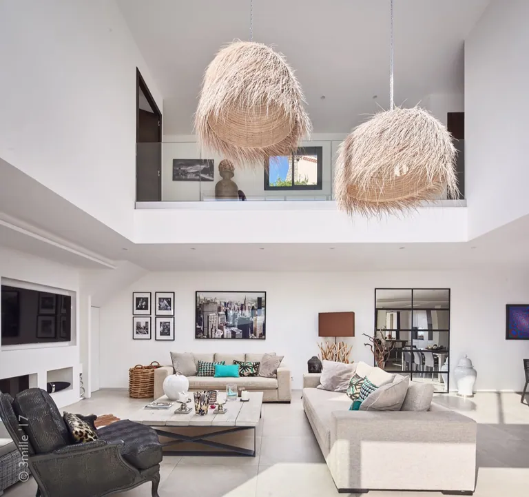 Living area beneath the double-height void, mezzanine with glass balustrade