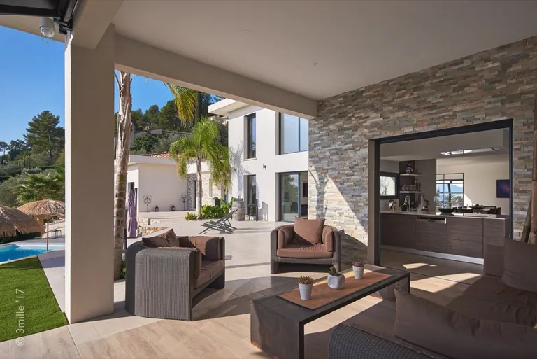 Covered terrace with outdoor lounge, opening onto the kitchen and garden