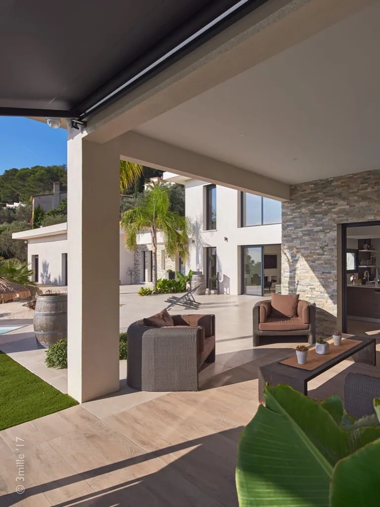 Outdoor lounge under the roof overhang, looking towards the villa and garden
