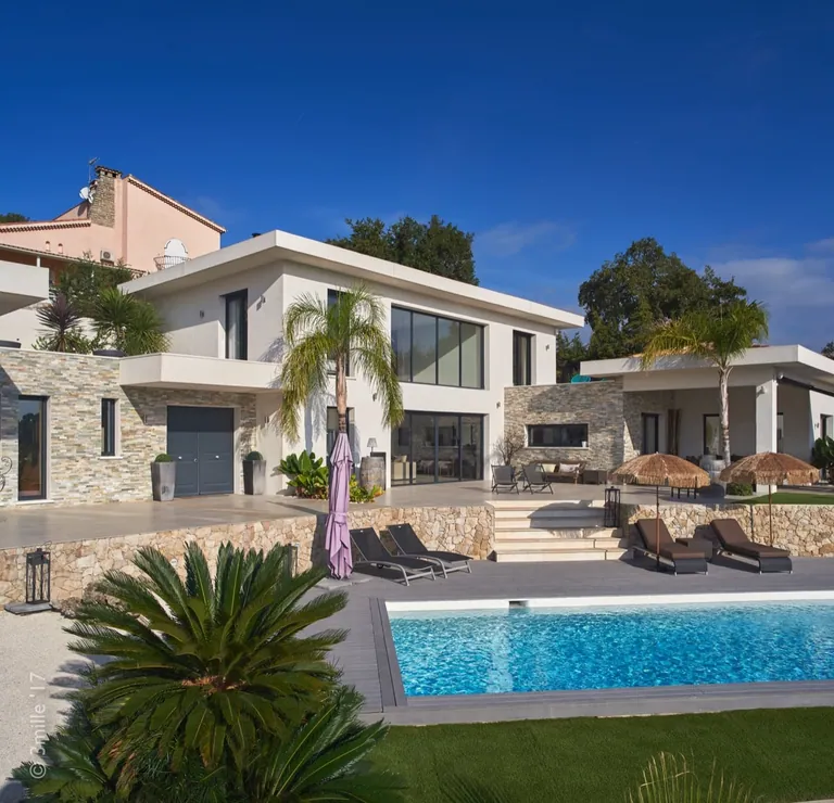 Main facade with front door, glazed openings and stone cladding above the pool