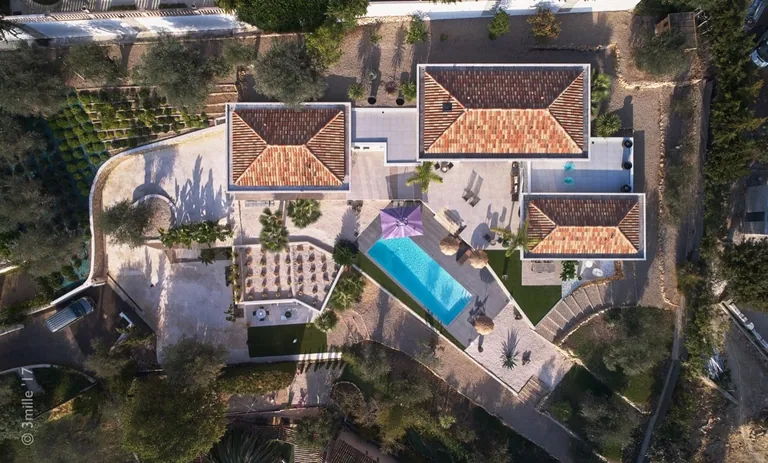 Top-down view of the tiled roofs, pool and terraces