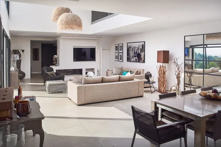 Bright open-plan living space: lounge, fireplace and dining table