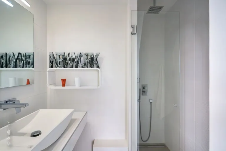 White shower room with basin and glass shower screen