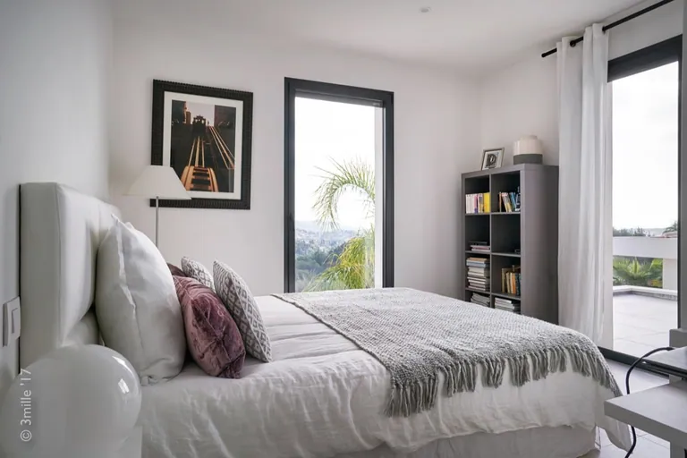 Light-toned bedroom with a view over the hills