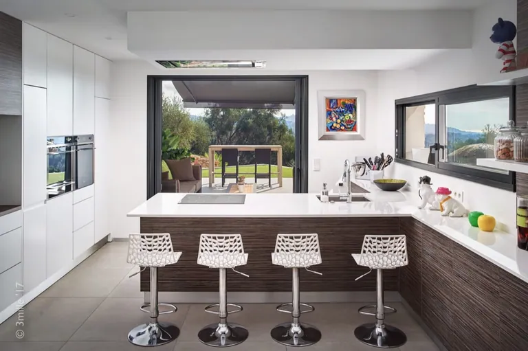Kitchen counter with bar stools, opening onto the covered terrace
