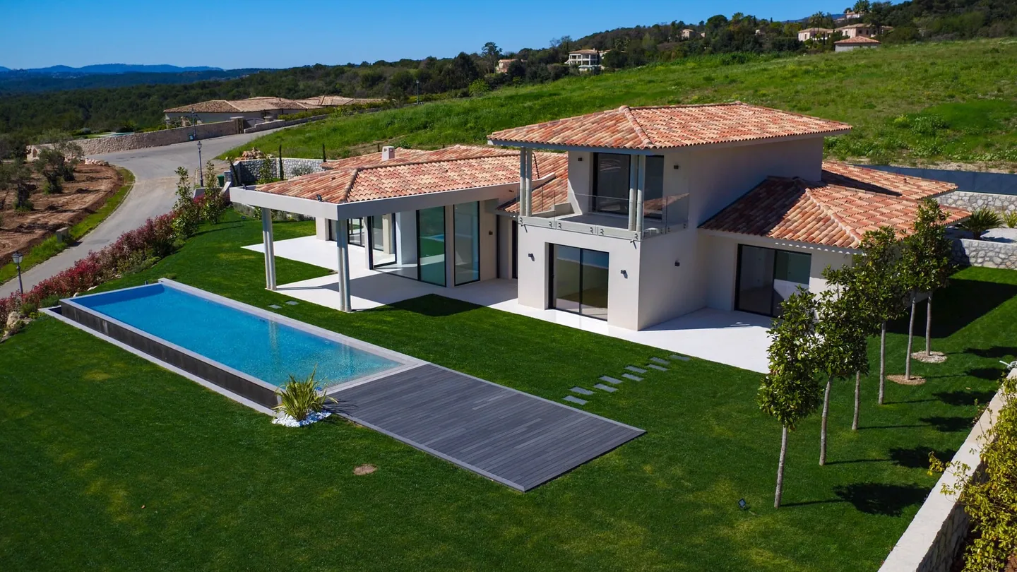 High-angle view of the pool, the deck and the villa facade
