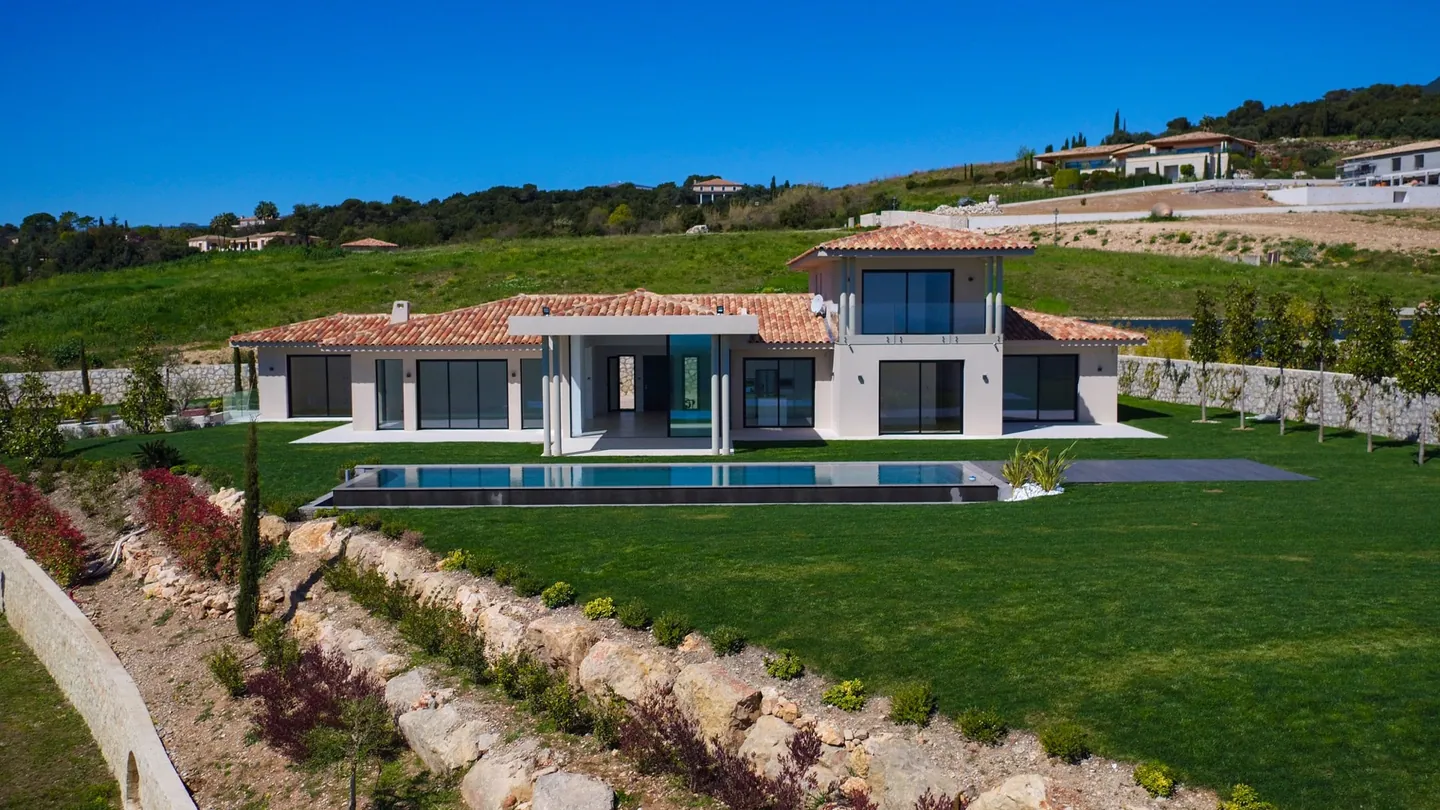 Landscaped rock embankment in front of the lawn, pool and villa
