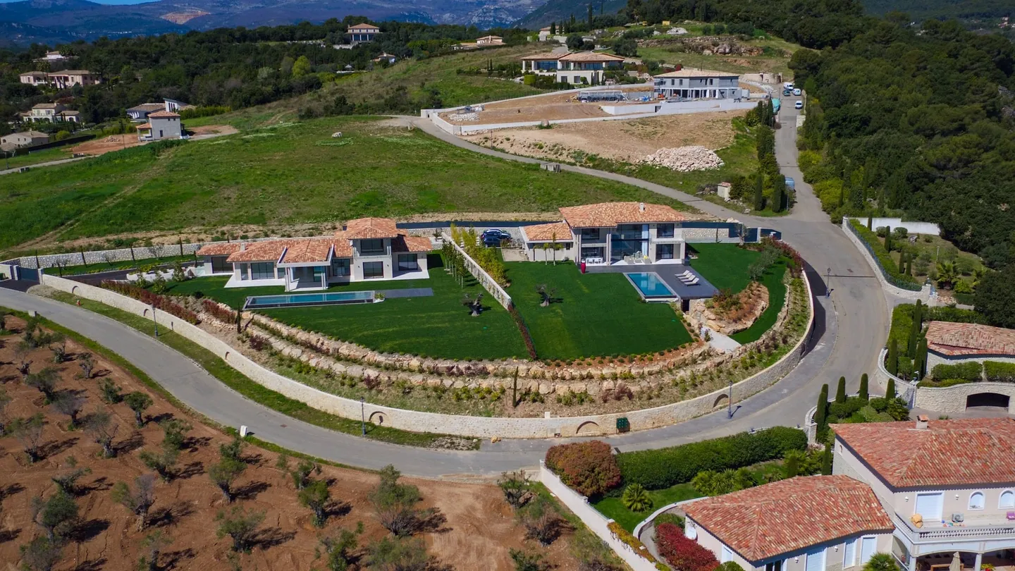 Aerial view of the landscaped plot, the stone walls and the villa
