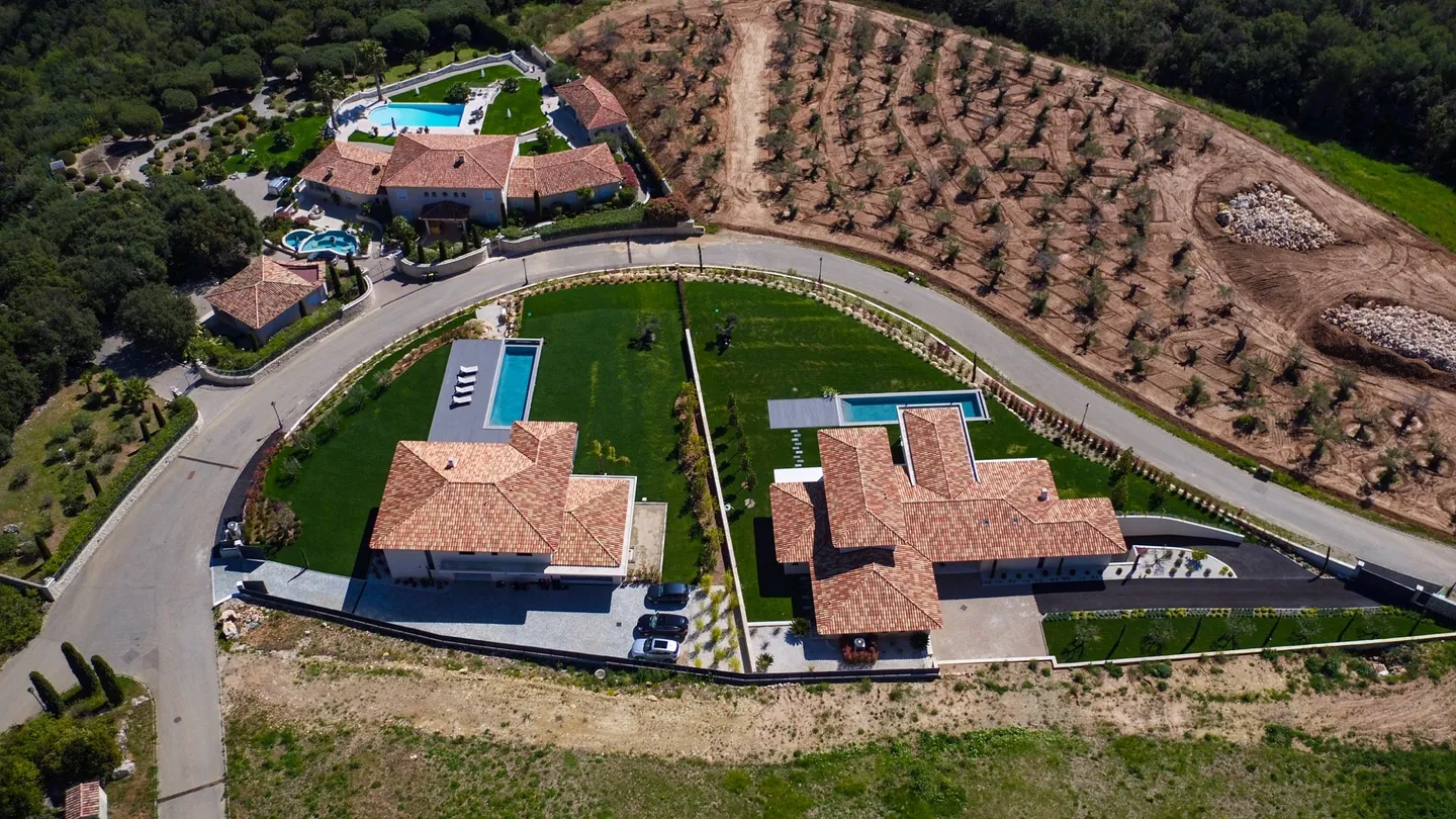 Top-down view of the tiled roofs, the pool and the garden