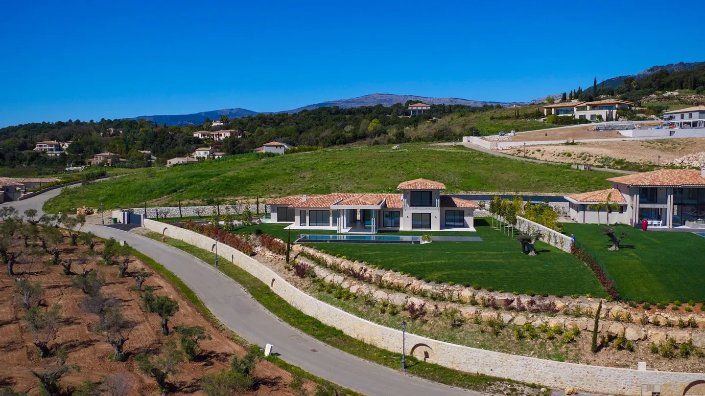 The villa and its terraced garden, bordered by a stone wall