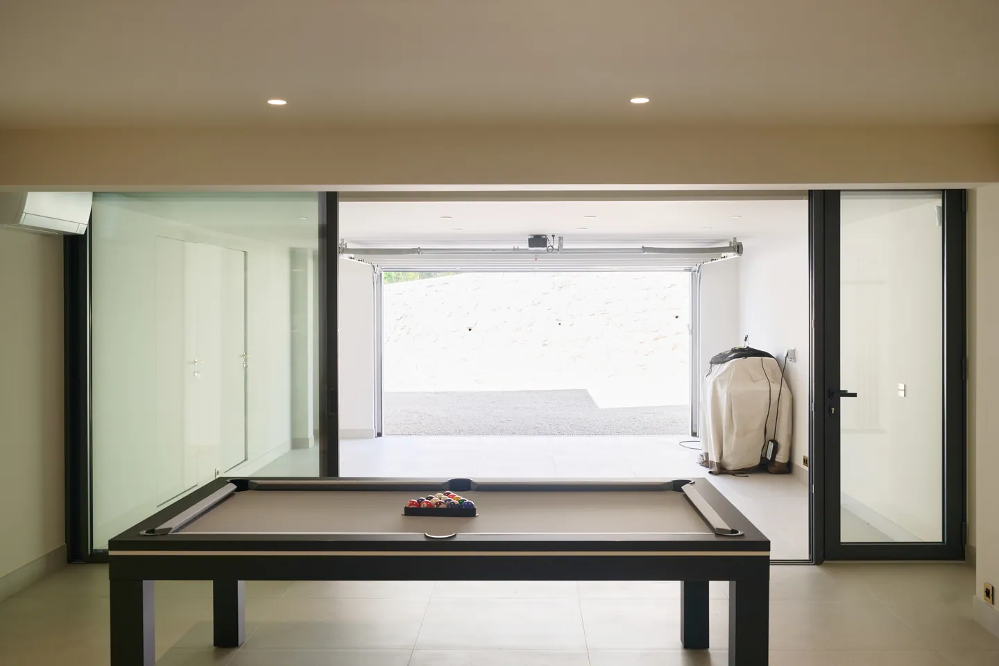 Billard devant une cloison vitrée donnant sur le garage