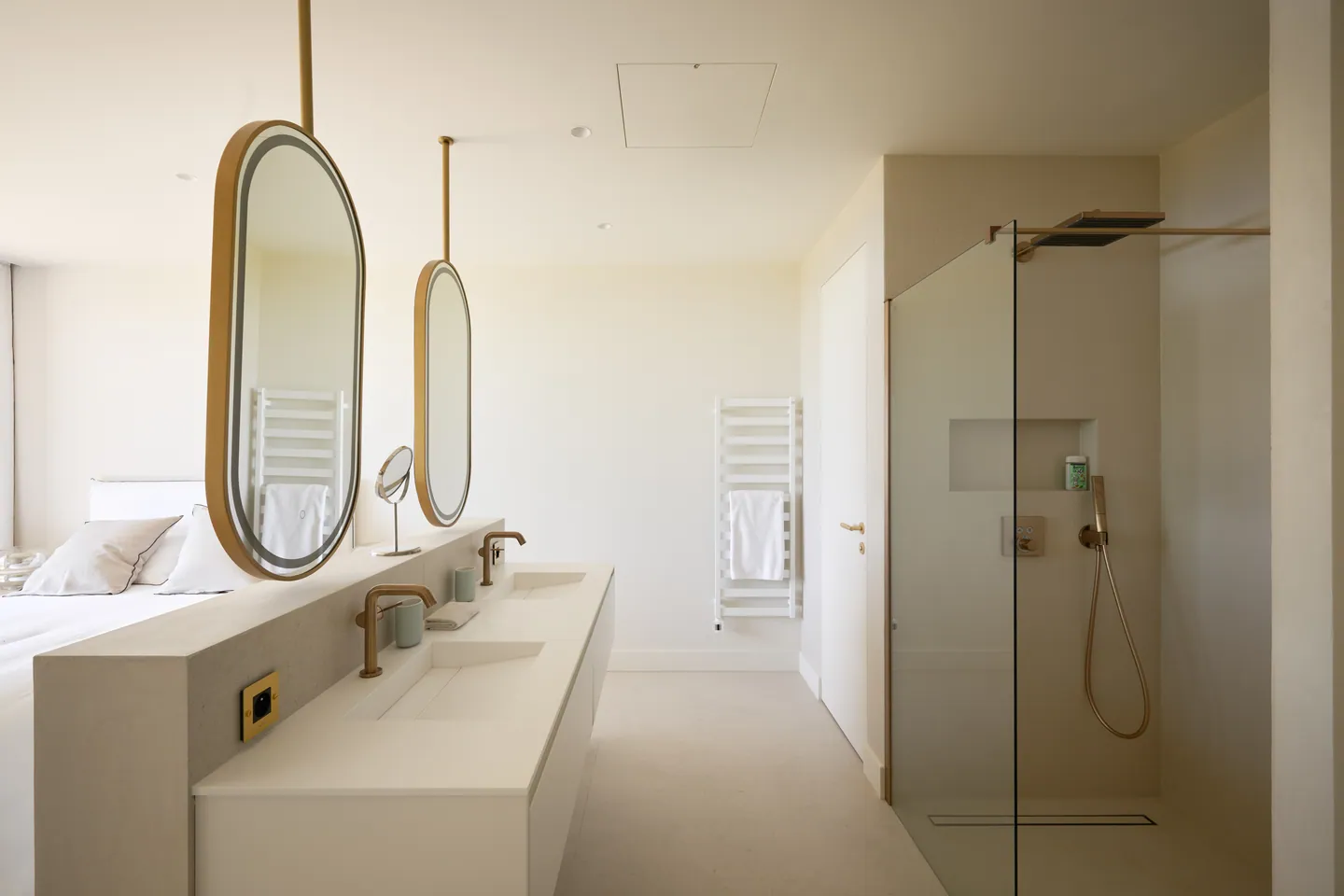 Double vasque, miroirs ovales cerclés de laiton et douche à l'italienne vitrée