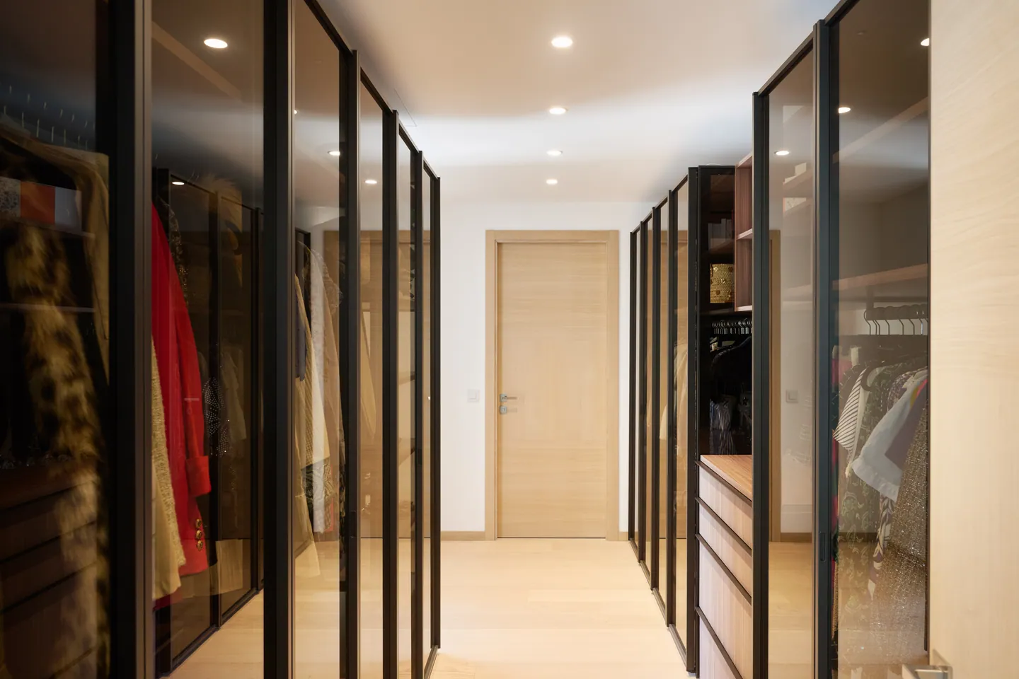 Dressing en couloir aux portes vitrées à cadre noir et parquet clair
