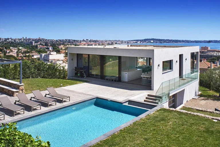 Cubic contemporary villa with pool and sun loungers, view over the town and the sea