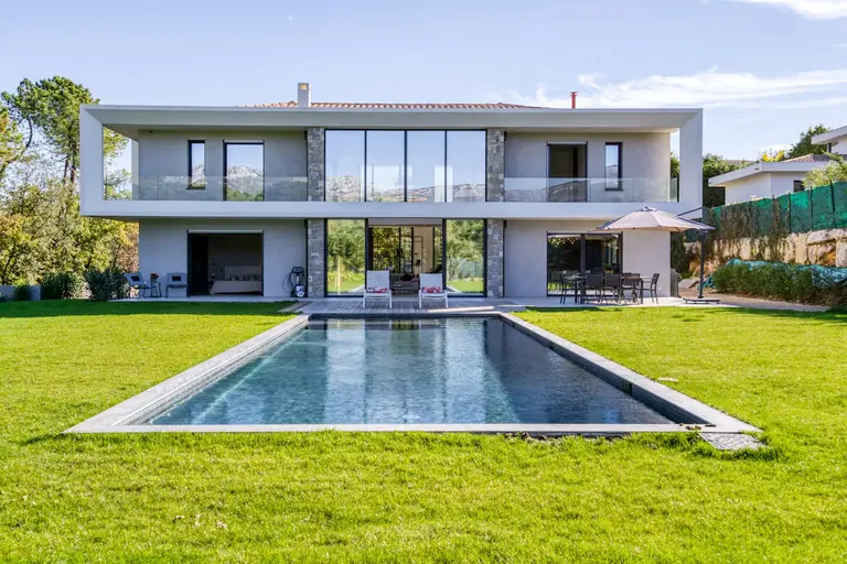 Two-storey contemporary villa with large glazing and a rectangular pool set in the lawn